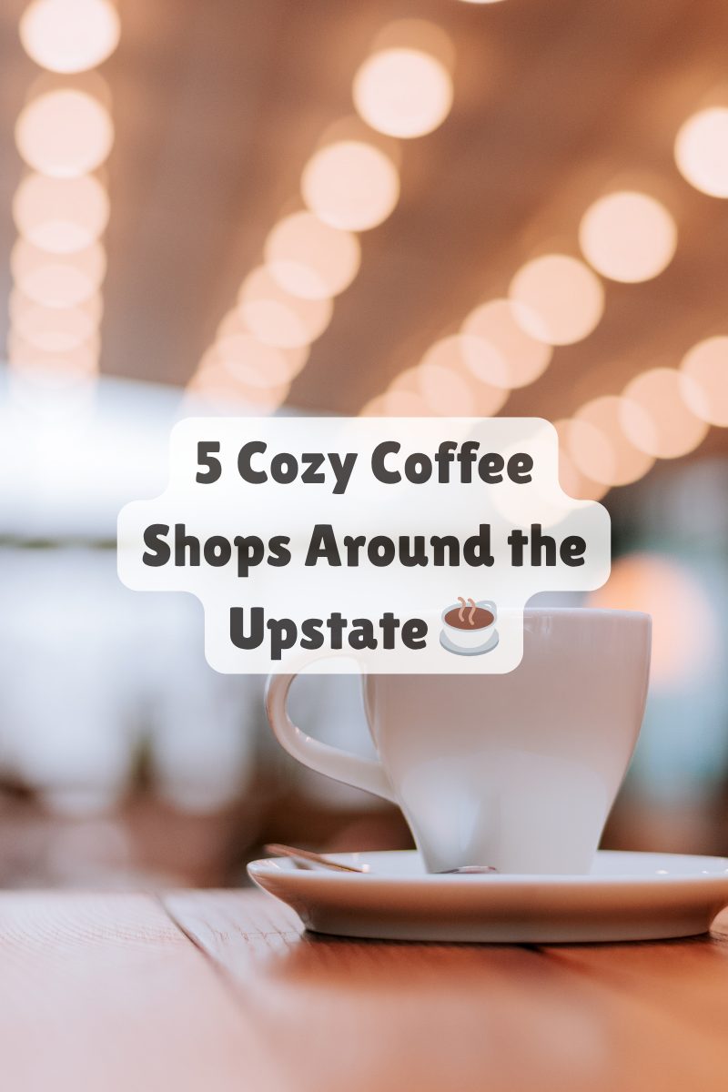 White coffee cup on a wooden table in a softly lit café, representing cozy local coffee shops in Upstate South Carolina.