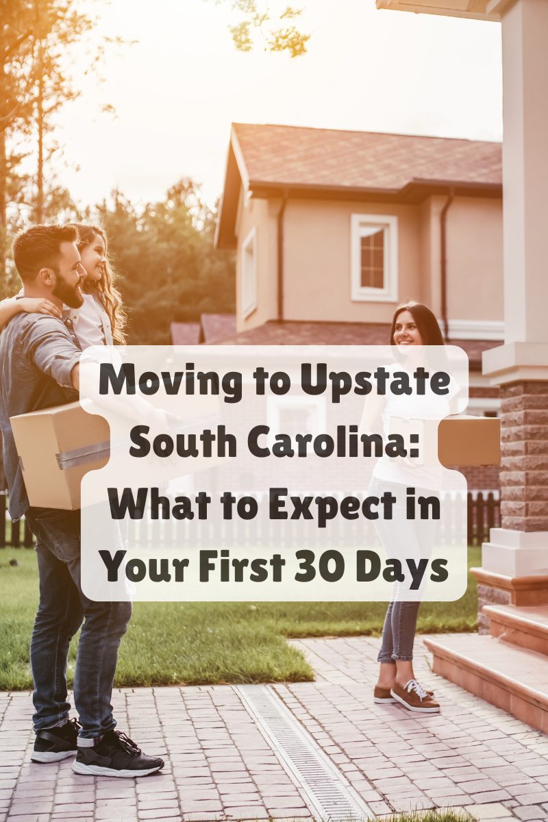 A couple carrying moving boxes while arriving at a home in a residential neighborhood, with warm evening light in the background.
